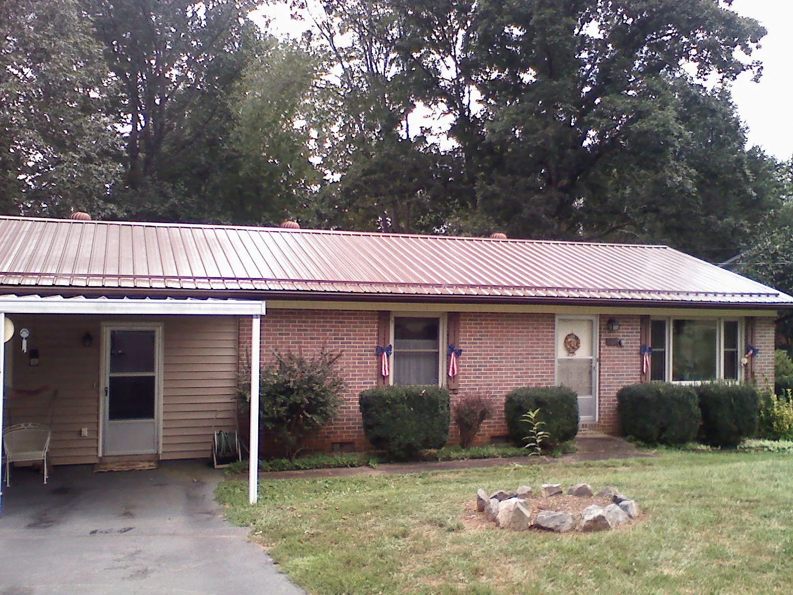 Bronze metal roof and carport on a brick ranch home — Roof Repair work by our crew in Bloomfield